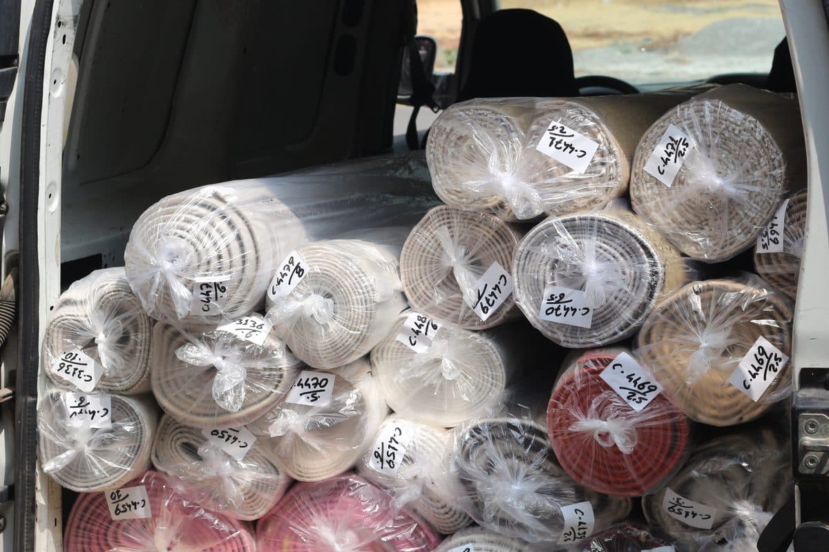 Naylonla paketlenip etiketlenmiş rulo hâlinde halılar servis aracında